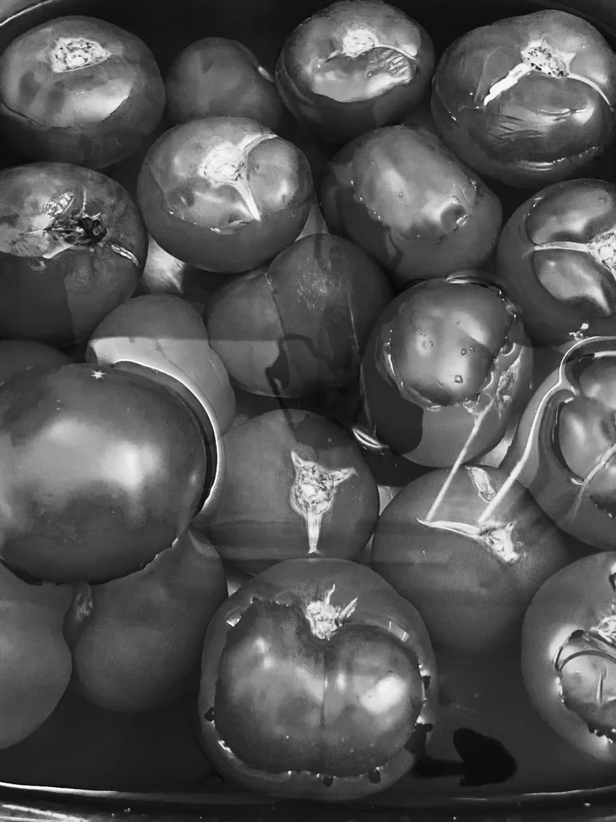 Tomates entières et coupées, vue rapprochée, reflets et noir et blanc.